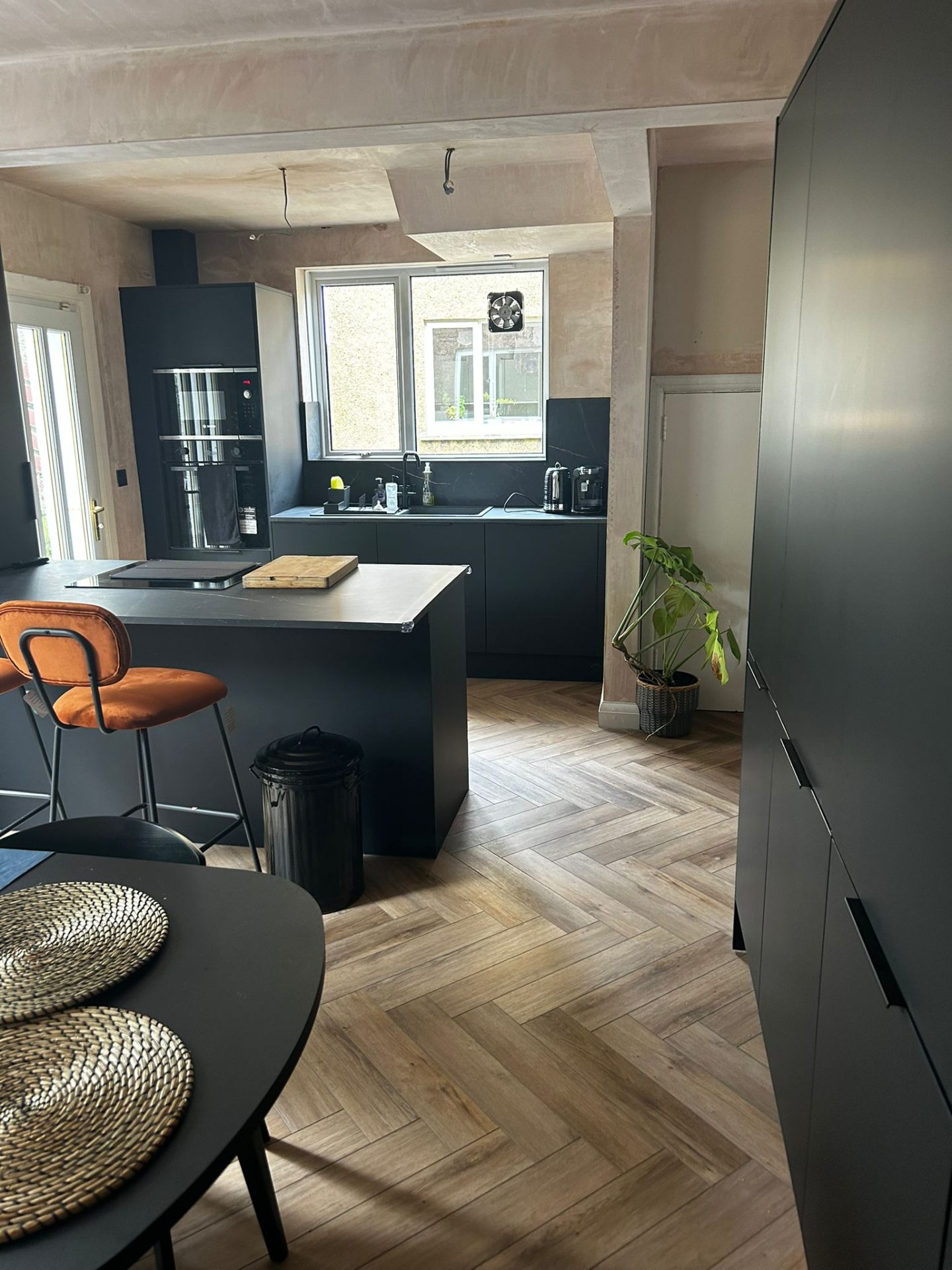 Matte navy kitchen with herringbone LVT flooring