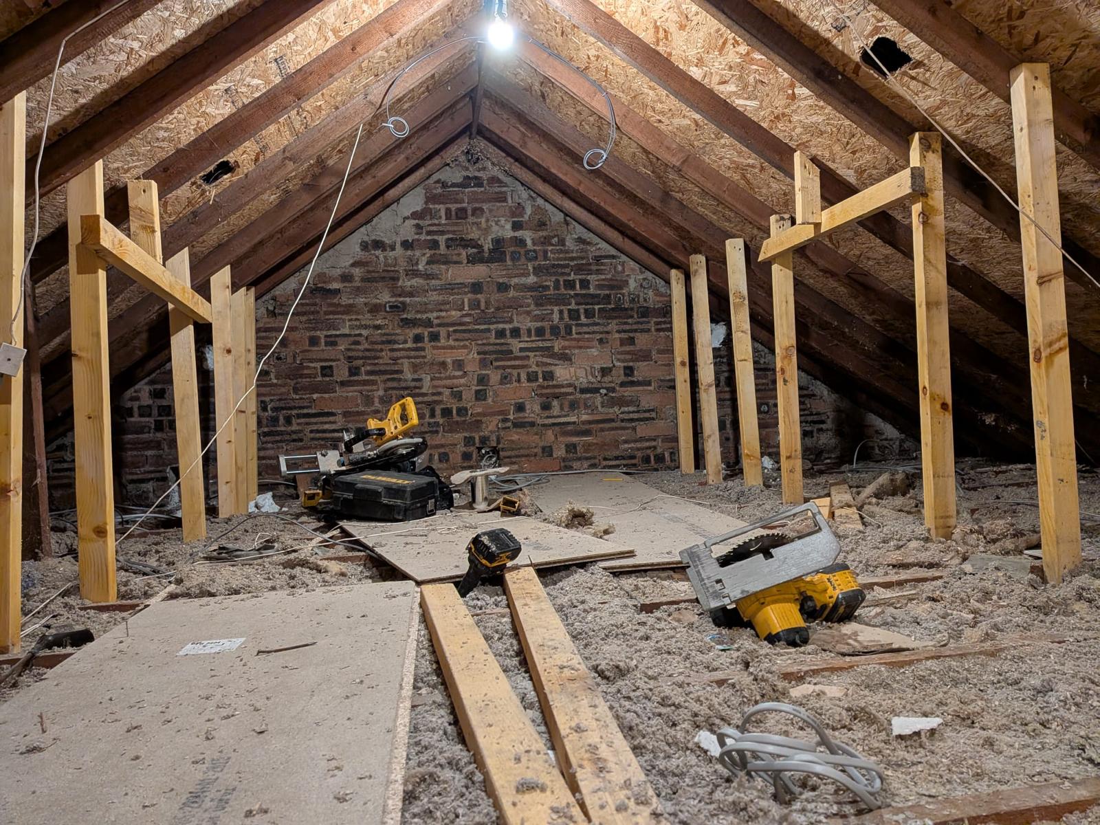 Before — raw Glasgow attic with open rafters, exposed brick and no floor